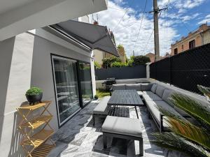 a patio with a bench and a table and chairs at Avignon maison à côté du tram et avec jacuzzy in Avignon