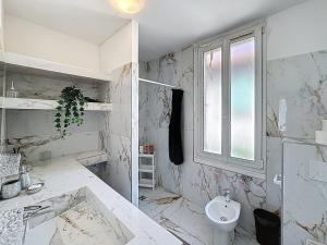 a white bathroom with a sink and a toilet at Avignon maison à côté du tram et avec jacuzzy in Avignon +12 photos