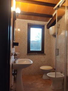 a bathroom with a sink and a toilet and a window at Agriturismo Collina degli Ulivi in Sarteano