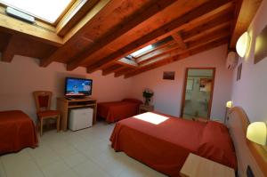 a bedroom with a bed and a television in a room at Hotel Tivoli in Lignano Sabbiadoro
