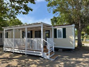 a white tiny house with a porch at The Beach Camping Village in Marina di Carrara +51 photos