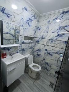 a bathroom with a toilet and a blue and white marble wall at La maison bleu in Oulad Akkou
