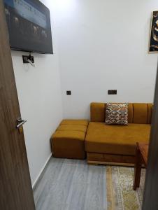 a living room with a couch and a flat screen tv at La maison bleu in Oulad Akkou