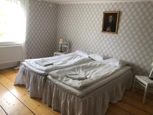 a bed in a bedroom with a picture on the wall at Mossebo Gästhem in Vimmerby