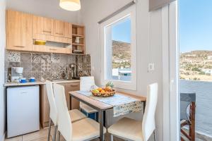 a kitchen with a table with a bowl of fruit on it at Porto Galini Tinos Myrsini 106 in Agios Ioannis Tinos