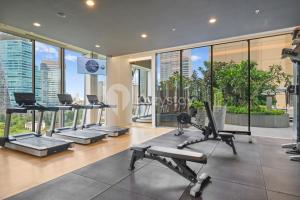 a gym with cardio equipment in a building with windows at Sivora by Kozystay - Kuningan in Jakarta