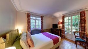 a bedroom with a bed and two windows at CAZAUDEHORE Hôtel Restaurant Gastronomique Terrasse et Jardins in Saint-Germain-en-Laye