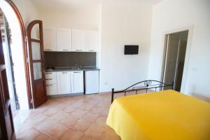 a kitchen with a yellow table in a room at Appartamenti Delfino in Lampedusa