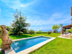 a pool with a statue next to a yard at Villa Blue Horizon - Panoramic Pools Cannes in Cannes