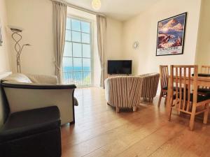 a living room with a table and a dining room at Harbour View in Ilfracombe