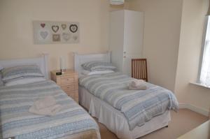 two beds in a bedroom with towels on them at Harbour View in Ilfracombe