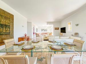 a living room with a glass table and chairs at Villa Blue Horizon - Panoramic Pools Cannes in Cannes
