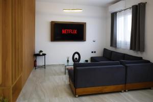 Una sala de estar con un sofá y un reloj en la pared. en Lavish Living Suite Heraklion Crete, en Kato Gouves
