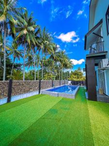 a backyard with a swimming pool and green grass at Keluang Hillside Villa Besut, Terengganu in Kampung Raja