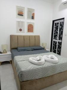 a bed with two white towels on it in a bedroom at Keluang Hillside Villa Besut, Terengganu in Kampung Raja