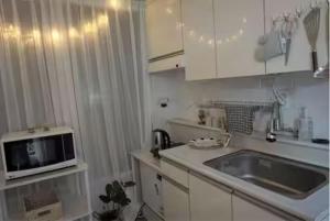 una piccola cucina con lavello e microonde di Koong House a Seul
