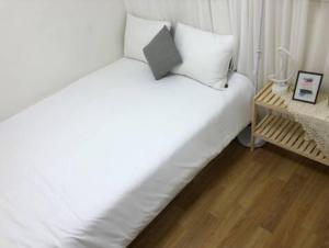 una camera con letto bianco e pavimento in legno di Koong House a Seul