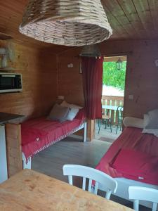 Zimmer mit 2 Betten und einem Tisch in einer Hütte in der Unterkunft La Roulotte Authentique au pays de George Sand avec piscine in Mouhers + 10 Fotos