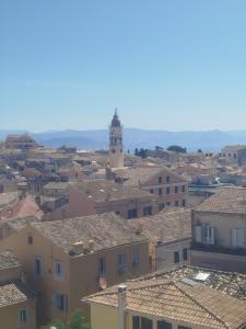 a view of a town with houses and a clock tower at Antigoni old town Apartment in Corfu