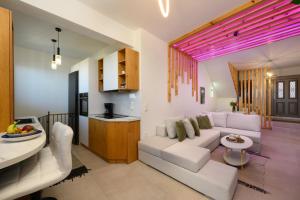 a living room with a white couch and a table at Thea Divine Comfort & View in Áyioi Dhéka