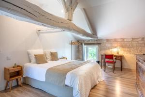 a bedroom with a bed and a desk in a room at Les Jardins de Xanton in Xanton-Chassenon +32 photos