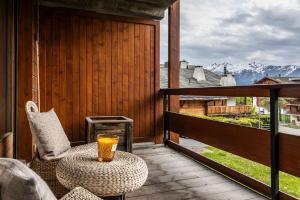 a drink on a table on the balcony of a cabin at La Ruinette-spacious studio in Verbier centre in Verbier