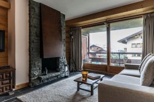 a living room with a couch and a fireplace at La Ruinette-spacious studio in Verbier centre in Verbier