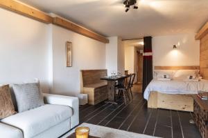 a hotel room with a bed and a couch and a desk at La Ruinette-spacious studio in Verbier centre in Verbier
