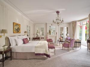 une chambre avec un grand lit et un salon dans l'établissement Hôtel Plaza Athénée - Dorchester Collection, à Paris