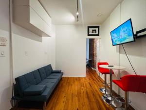 a living room with a couch and a tv at Fifty West New York in New York