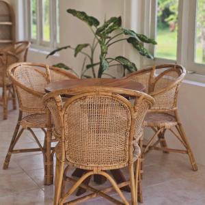 a wooden table with wicker chairs and a plant at CoViva in Kumbalgama