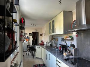a kitchen with white cabinets and a counter top at Maison de ville in Saint-Jean-dʼAngély +9 photos