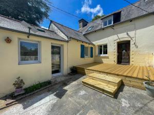 eine Holzterrasse an der Seite eines Hauses in der Unterkunft Le Goêllo in Paimpol