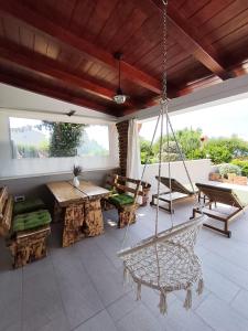 a porch with a swing and a hammock at Apartments Tinjarosa in Mundanije