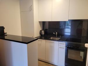 een keuken met witte kasten en zwarte aanrechtbladen bij Haus Perle in Saas-Fee +2 foto's