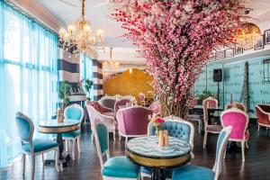 a restaurant with tables and chairs and pink flowers at River Side Hotel Tbilisi in Tbilisi City +37 photos