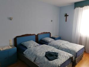 two beds in a room with a cross on the wall at Maison individuelle à Issenheim in Issenheim