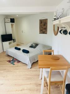 a bedroom with a bed and a wooden table at Anglet Chiberta - Proche plage -Terrasse in Anglet