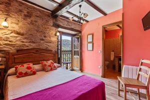 a bedroom with a large bed with pink walls at Lago Gabriel - Villar de Posada in Caldevilla de Rengos