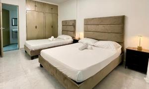 a bedroom with two beds and a bathroom at Apartamentos cerca a canchas Panamericanas Barrio Olimpico - Luxury Apartments in Cali