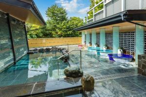 una piscina con una fontana di fronte a un edificio di 神通峡春日温泉ゆーとりあ越中 a Toyama