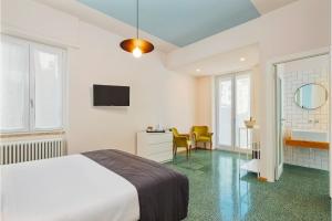 a bedroom with a bed and a desk and a tv at La Casa delle Acciughe Guest House in La Spezia