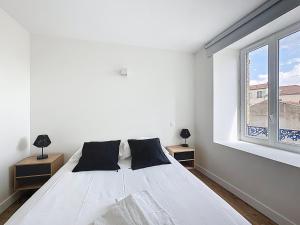 a white bedroom with a bed and a window at Mcosy 5, T2, 4 personnes, clim, proche A75 in Coudes