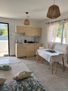 a living room with a table and a kitchen at Les jardins de Saint Pancrace in Corte
