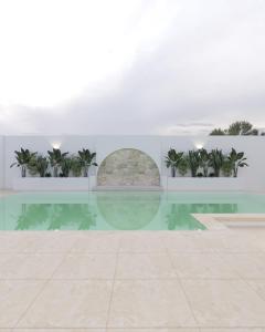 a pool with palm trees in a building at Villa Ayem avec piscine à l'étage in Al Ḩārah al Kabīrah