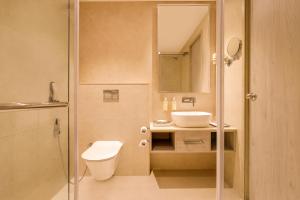 a bathroom with a toilet and a sink at Lemon Tree Hotel, Jamnagar in Jamnagar +54 photos