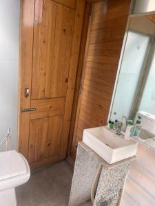 a bathroom with a sink and a toilet and a mirror at Okho Resort Kalka Panchkula in Kālka