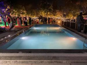 a group of people standing around a pool at night at Okho Resort Kalka Panchkula in Kālka