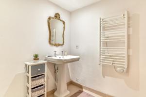 a white bathroom with a sink and a mirror at Au Pied de la Cité - Terrasse - Climatisation - Wifi in Carcassonne +38 photos