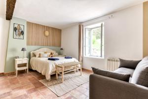 a bedroom with a bed and a living room with a couch at Au Pied de la Cité - Terrasse - Climatisation - Wifi in Carcassonne